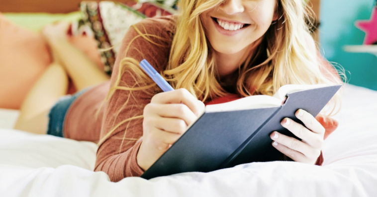 young woman writing in journal