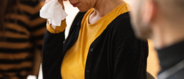 crying older woman flanked by two people