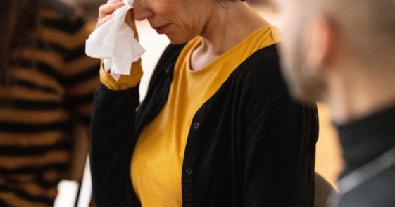 crying older woman flanked by two people
