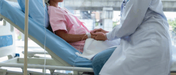 teenage girl in hospital bed with doctor