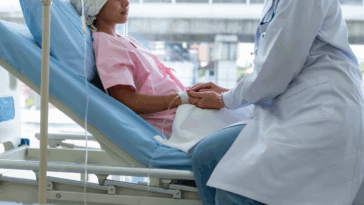 teenage girl in hospital bed with doctor