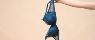 Woman is showing off a new blue bra in the hand. Choosing a new bra concept.