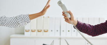 A woman pushing a phone away with her hand.