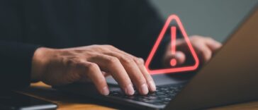 Businessman or it staff , programmer, developer using computer laptop with triangle caution warning sign for notification error and maintenance concept.