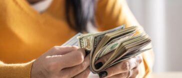 A woman counts many American bills - Close up.