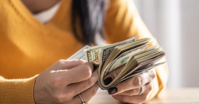A woman counts many American bills - Close up.