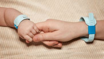 Baby holding their parent's hand