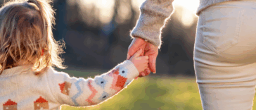 Woman holding hands with her child