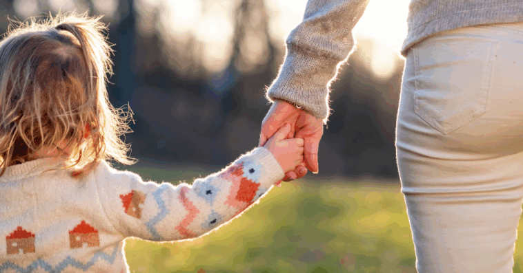 Woman holding hands with her child