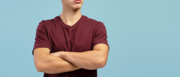 A teenage boy with his arms crossed.