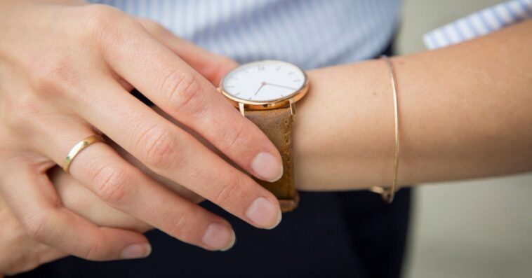 Businesswoman wearing wrist watch, close-up.