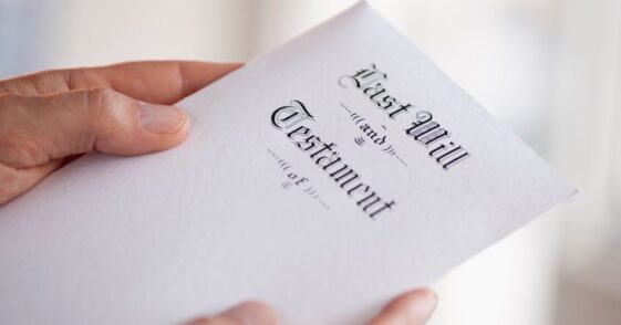 Up close shot of a man's hand holding a last will and testament.