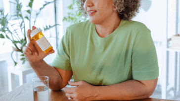 A woman holding a prescription bottle.