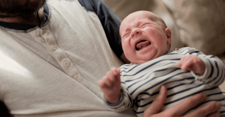 man holding crying infant