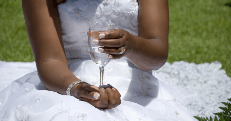 Bride holding flute glass filled with water