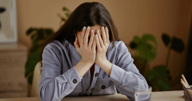 depressed young woman with face in hands