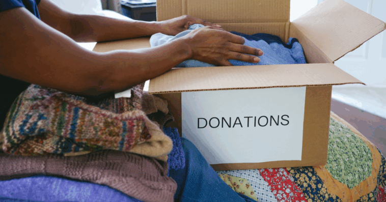 A woman packing a box labeled "donation box" on it.