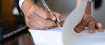 A man signing a paper document.