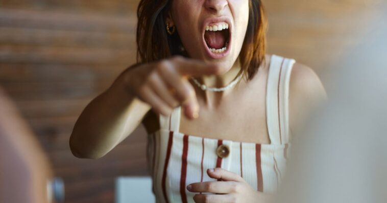 Displeased woman screaming in frustration while arguing with her boyfriend.
