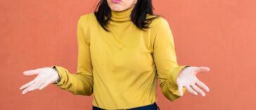 A woman shrugging with her hands to the sides.