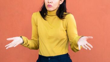 A woman shrugging with her hands to the sides.