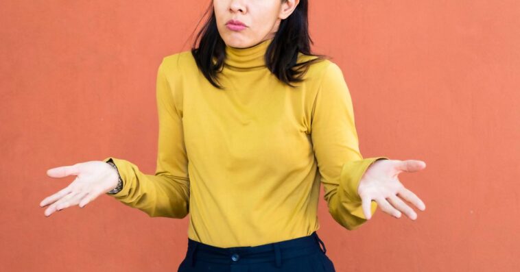 A woman shrugging with her hands to the sides.