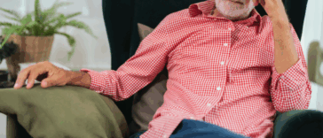 A man sitting back in a lounger chair with his head in his forehead.