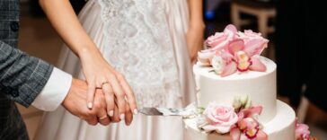 Newlyweds cutting wedding cake.
