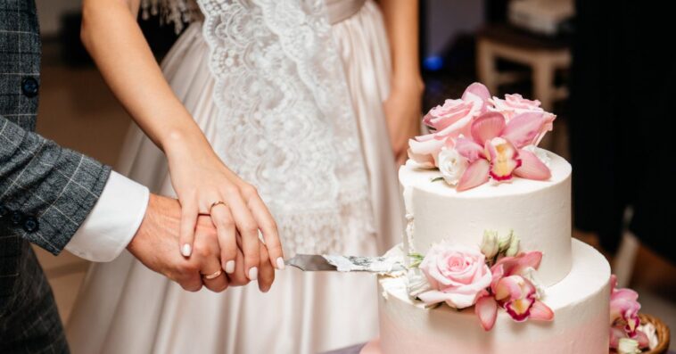 Newlyweds cutting wedding cake.