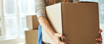 A woman holding a moving box.