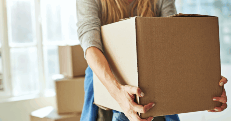 A woman holding a moving box.