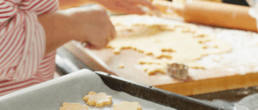person cutting out cookies