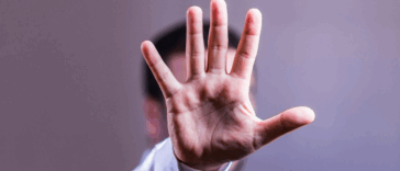 man holding his hand up tpo indicate "stop"