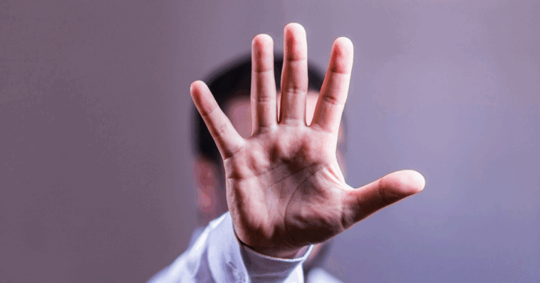 man holding his hand up tpo indicate "stop"