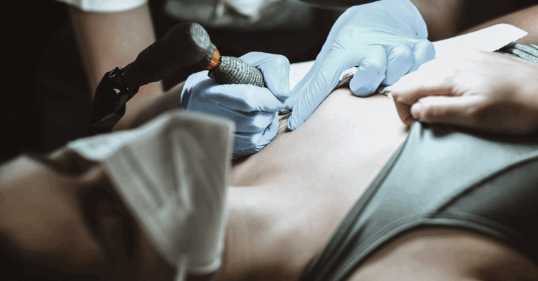 woman getting tattoo on her chest
