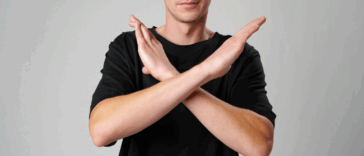 A person holding their arms in an X shape.