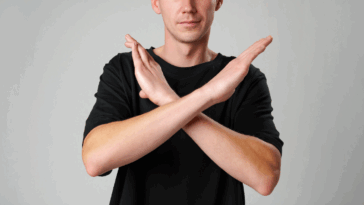 A person holding their arms in an X shape.