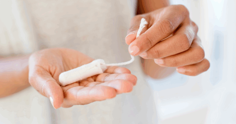 A woman holding a tampon in her hands.
