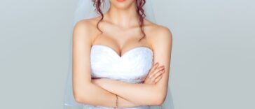 Grumpy bride. Sad and disappointed hesitating woman in wedding dress, arms folded, unhappy wife.