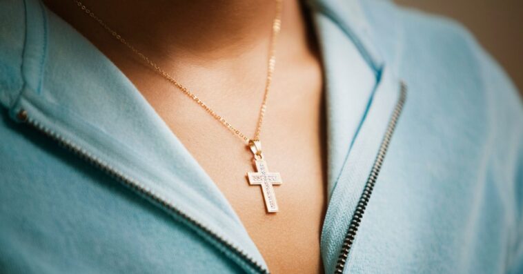 Close up of a cross necklace on woman.