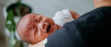 A man holding a crying baby.