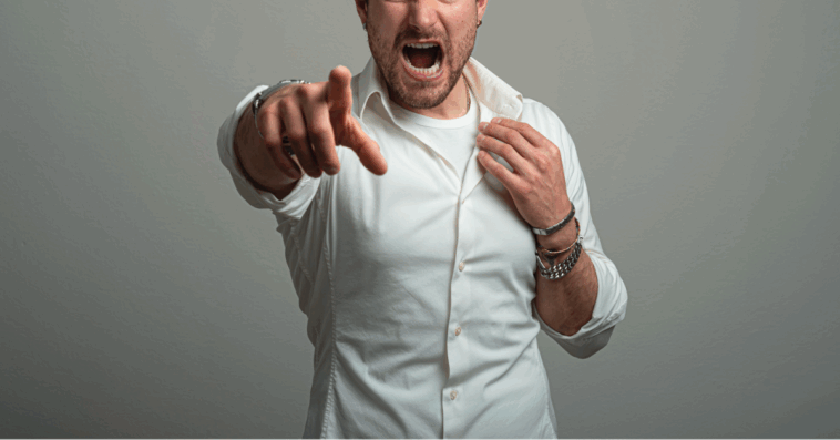 A man screaming and pointing his finger at the camera.