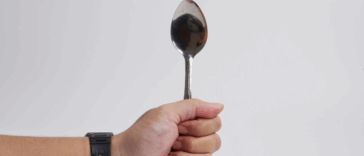 A person holding a spoon upright.