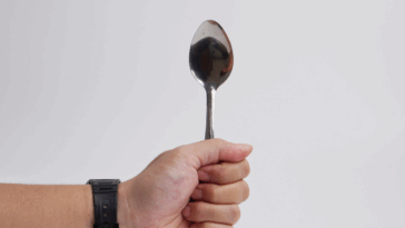 A person holding a spoon upright.