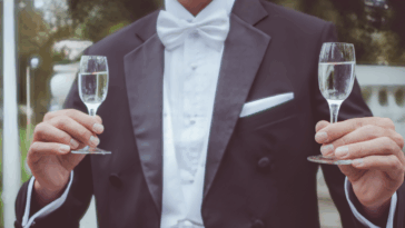 groom holding two glasses of champagne