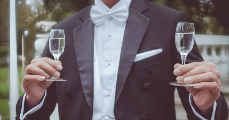 groom holding two glasses of champagne