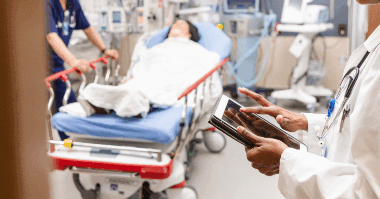 A doctor standing in the foreground of a hospital wing.
