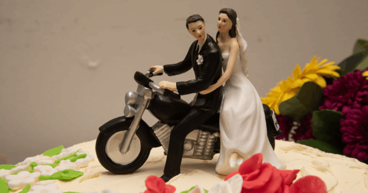 wedding cake topper with bride and groom on motorcycle