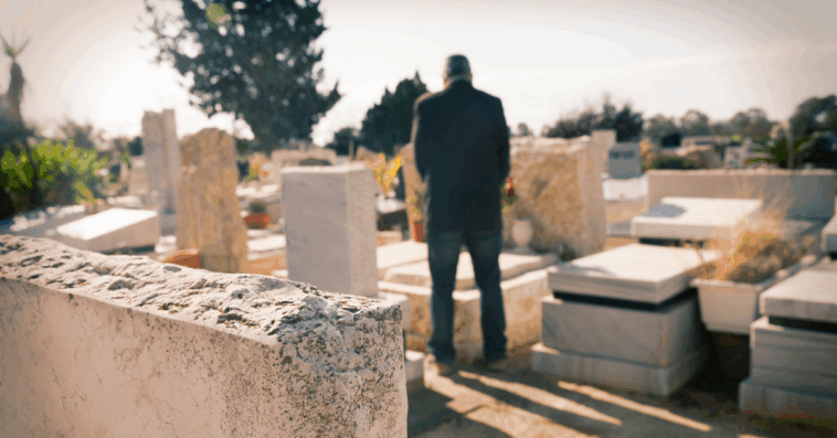 Man standing at gravesite