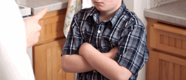 young boy reacts to being scolded